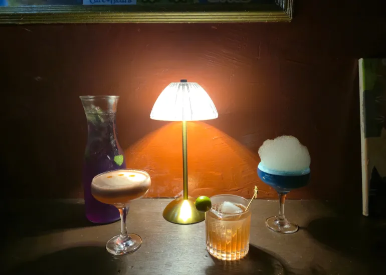 Blue Door 304 interior showing cocktails beautifully lit by table lamps in the intimate speakeasy setting