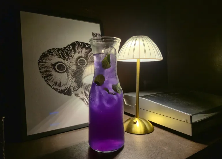 Blue Door Mojito, a vibrant purple cocktail in a glass carafe with mint leaves