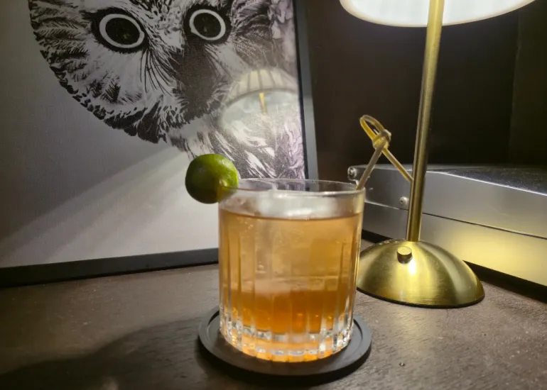 Summer Rain cocktail at Blue Door 304, an amber drink with calamansi garnish